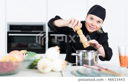 Female cook is making soup on her work place in the kitchen Female cook is making soup on her work place in the kitchen 46613443
