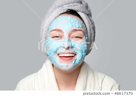 Woman applying facial clay mask at spa salon or at home, skincare theme. Face mask, spa beauty Woman applying facial clay mask at spa salon or at home, skincare theme. Face mask, spa beauty 46617370