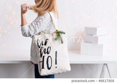 Unrecognizable woman holding Christmas gift in cloth bag. Happy winter holidays. Presents for Unrecognizable woman holding Christmas gift in cloth bag. Happy winter holidays. Presents for 46617808