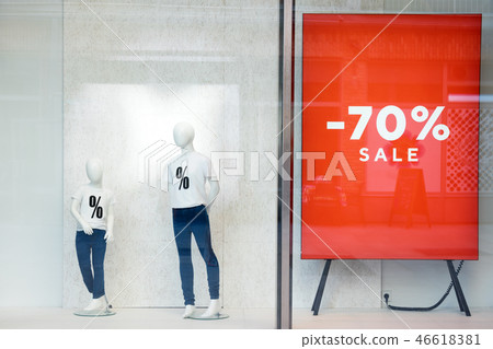 Shopping sale window display with mannequins wearing t-shirts with sign of Sale. Dummies in the 46618381