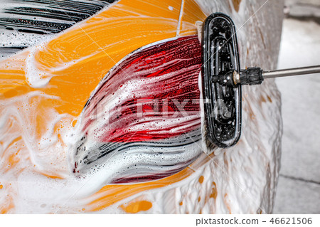 Brush leaving strokes in soap foam of yellow car 46621506