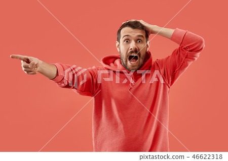 The young emotional angry man screaming on coral studio background 46622318