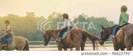 Kids learn to ride a horse near the river Kids learn to ride a horse near the river 46622742