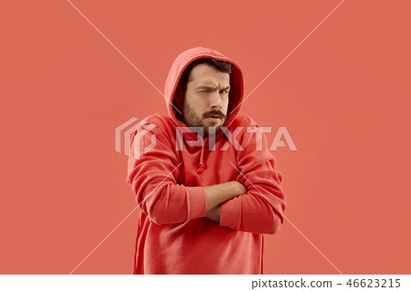 Suspiciont. Doubtful pensive man with thoughtful expression making choice against coral background Suspiciont. Doubtful pensive man with thoughtful expression making choice against coral background 46623215