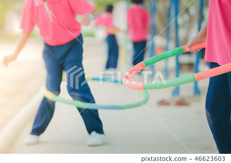 Female students doing exercise with a hula-hoop Female students doing exercise with a hula-hoop 46623603