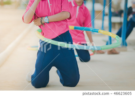 Female students doing exercise with a hula-hoop Female students doing exercise with a hula-hoop 46623605