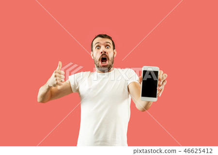 Young handsome man showing smartphone screen isolated on coral background in shock with a surprise 46625412