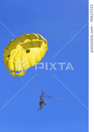 Young active couple enjoying flying with parachute, extreme parasailing activity Young active couple enjoying flying with parachute, extreme parasailing activity 46625583