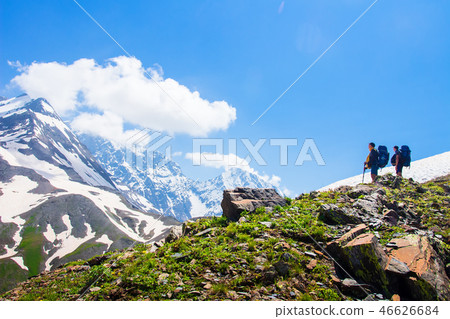 Climbers look at rocky summit covered by snow Climbers look at rocky summit covered by snow 46626684