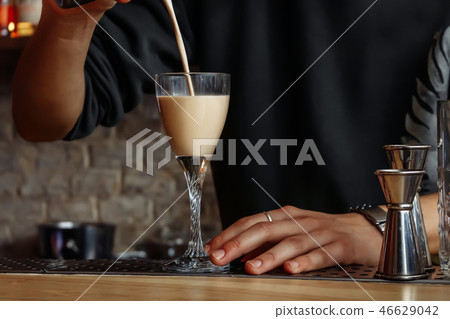 The barman is preparing a cocktail.  46629042