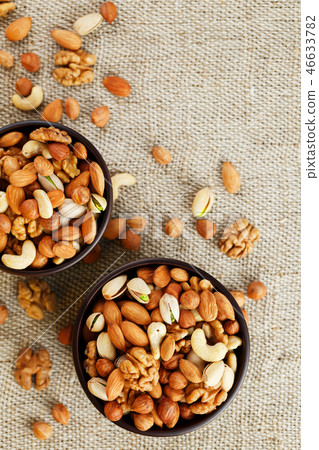 Mix of various nuts in a wooden cup against  46633782