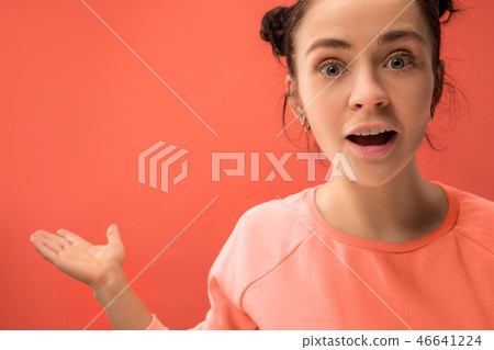 Beautiful woman looking suprised isolated on coral Beautiful woman looking suprised isolated on coral 46641224