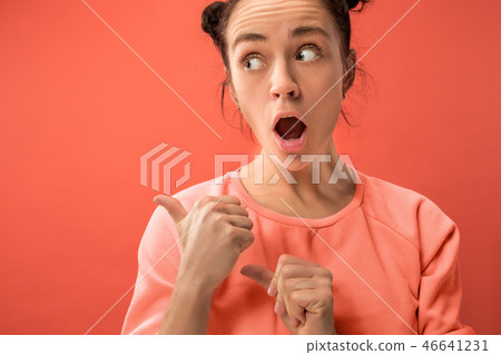 Beautiful woman looking suprised isolated on coral Beautiful woman looking suprised isolated on coral 46641231