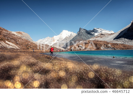 Tourist backpacker hiking on peak at Milk lake Tourist backpacker hiking on peak at Milk lake 46645712