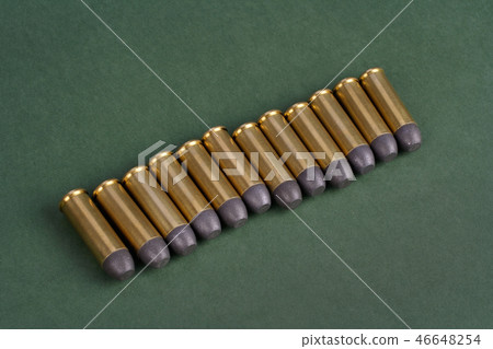 Western-style revolver cartridges on green Western-style revolver cartridges on green 46648254