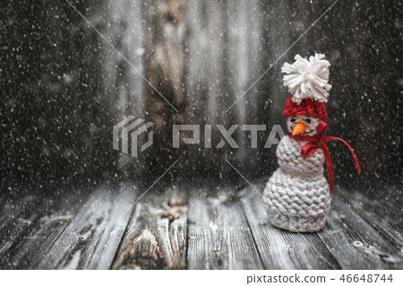 New Year winter snowman decoration with snow on black wooden background. Holiday New Year postcard New Year winter snowman decoration with snow on black wooden background. Holiday New Year postcard 46648744