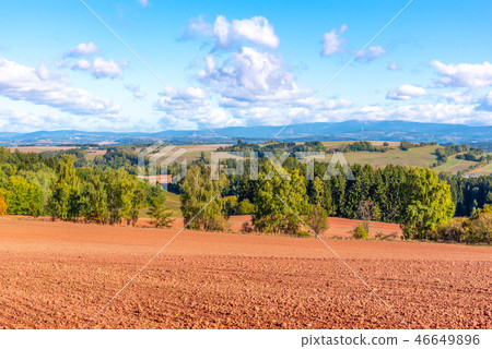 Typical red soil of countryside around Nova Paka. Agricultural Landscape with Giant Mountains on the Typical red soil of countryside around Nova Paka. Agricultural Landscape with Giant Mountains on the 46649896