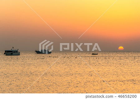 boat silhouetts on the shores of the red sea at sunset in Makadi Bay Egypt golden colors 46658200