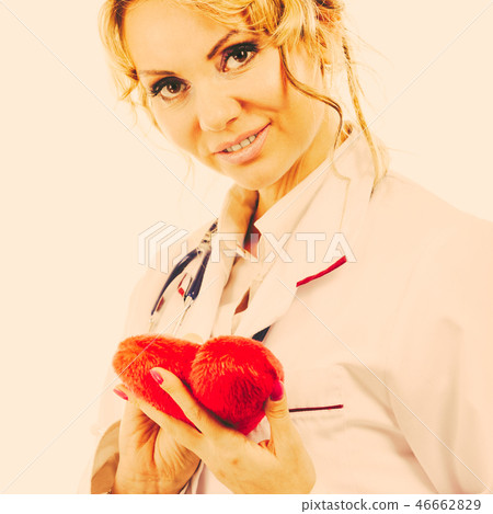 Doctor with stethoscope examining red heart. Doctor with stethoscope examining red heart. 46662829