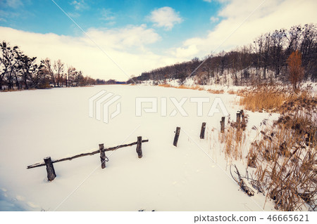 Winter landscape. Frozen lake covered with snow Winter landscape. Frozen lake covered with snow 46665621