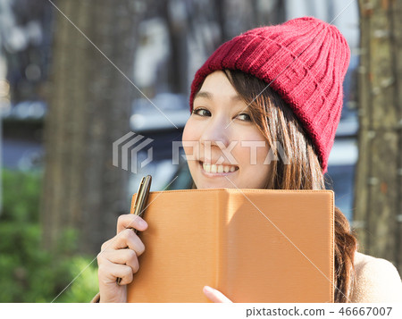 拿著橙色筆記本的想法的婦女 拿著橙色筆記本的想法的婦女 46667007