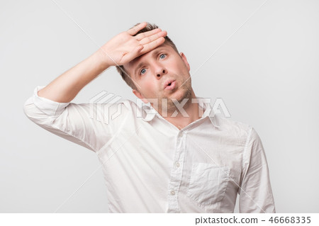Exhausted european man wipes the sweat of his forehead. 46668335