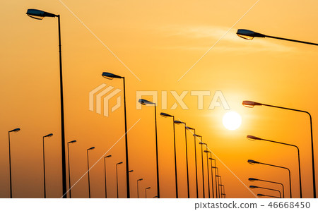 Street lamp poles and beautiful sunset sky. 46668450