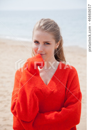 the woman in the Sweater walking on sandy beach, one sea coast 46668657