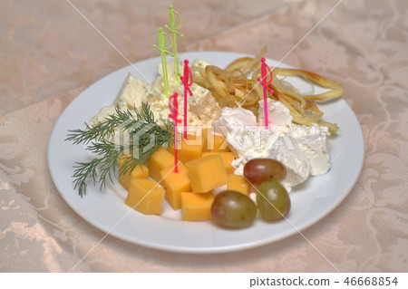 Various cheeses with greens and grapes on white 46668854