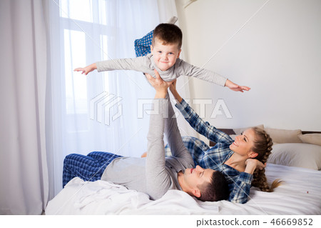 mom dad and young son sleep on the bed in the bedroom 46669852