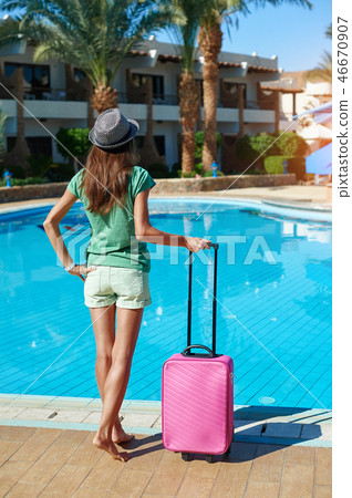 Travel, summer holidays and vacation concept - Beautiful woman walking near hotel pool area with 46670907
