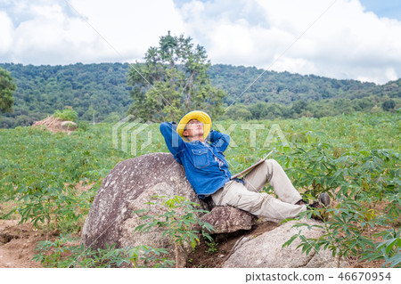 Agriculture sit under the tree.In the cassava farm 46670954