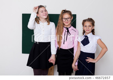 three girls in glasses at the Blackboard in a class lesson three girls in glasses at the Blackboard in a class lesson 46672857