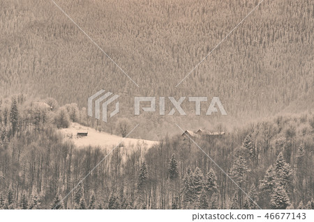 Snow-covered mountain slopes. Small house 46677143