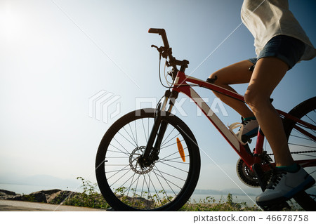 Hands free cycling woman riding bike on seaside 46678758