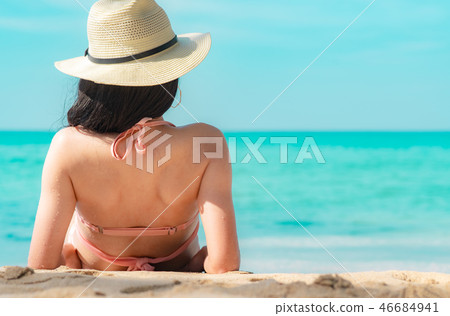 Asian woman in pink swimsuit and straw hat relax Asian woman in pink swimsuit and straw hat relax 46684941