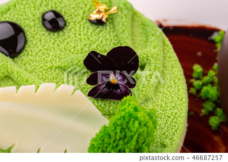 A green velor dessert with white chocolate and vio 46687257