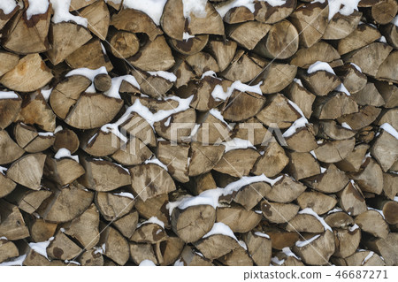 Chopped firewood on a stack in snow. Front view. Chopped firewood on a stack in snow. Front view. 46687271