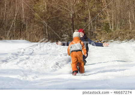The little boy in overalls running through snow 46687274