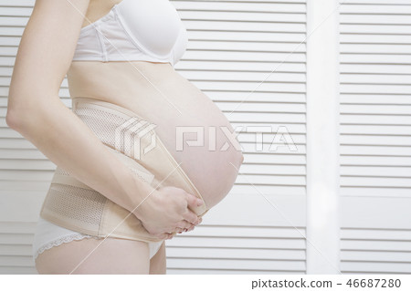 Woman puts on a bandage for pregnant women Woman puts on a bandage for pregnant women 46687280
