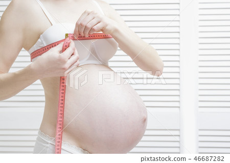 Pregnant woman measures breast volume 46687282