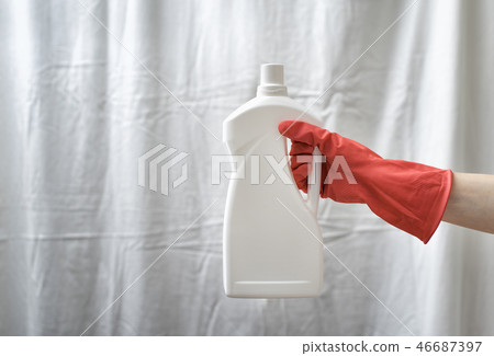 Gloved hand holding a big white bottle. Washing Gloved hand holding a big white bottle. Washing 46687397