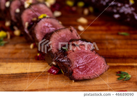 Venison pieces on a board with dried tomatoes Venison pieces on a board with dried tomatoes 46689090