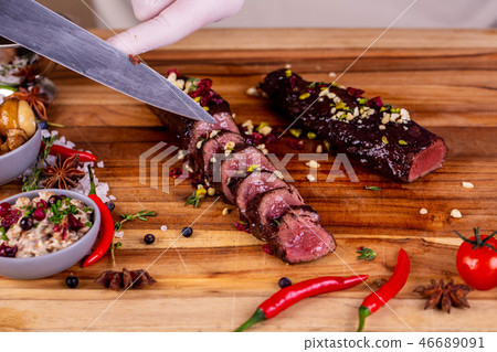 The cut venison on a board with nuts, pearl barley 46689091