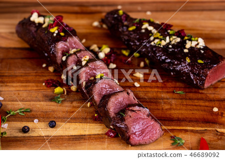The meat pieces cut on a wooden board with hazelnu 46689092