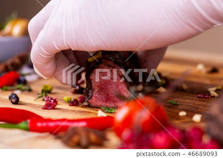 The cook cuts venison brisket with vegetables and The cook cuts venison brisket with vegetables and 46689093