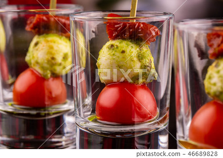 Portion giving of cheese mozzarella with dried tom Portion giving of cheese mozzarella with dried tom 46689828