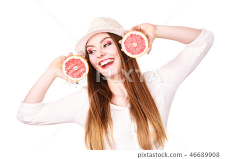Woman holds two halfs of grapefruit citrus fruit in hands 46689908