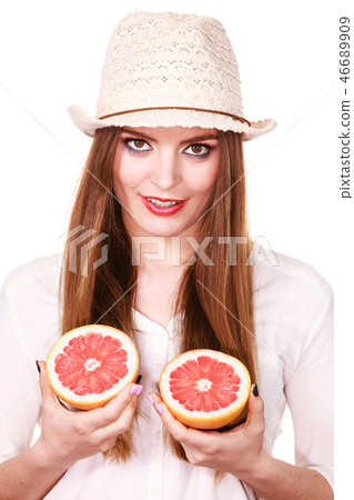 Woman holds two halfs of grapefruit citrus fruit in hands Woman holds two halfs of grapefruit citrus fruit in hands 46689909