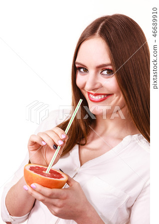 Woman holds grapefruit drinking juice from fruit Woman holds grapefruit drinking juice from fruit 46689910